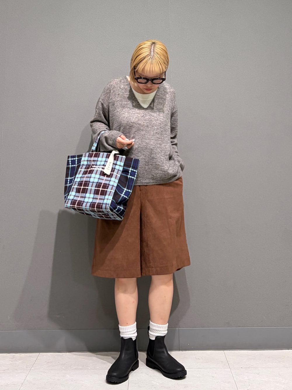 グレー系のニット/セーター、ブラウン系のその他パンツ、ブラック系のレインシューズを着用したレディースの秋コーディネートの2枚目の写真