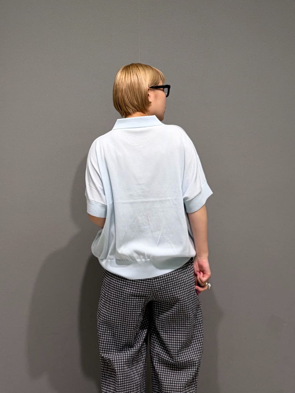 ブラック系のその他パンツ、ブルー系のニット/セーター、シルバー系のアナログ腕時計を着用したレディースの夏コーディネートの2枚目の写真