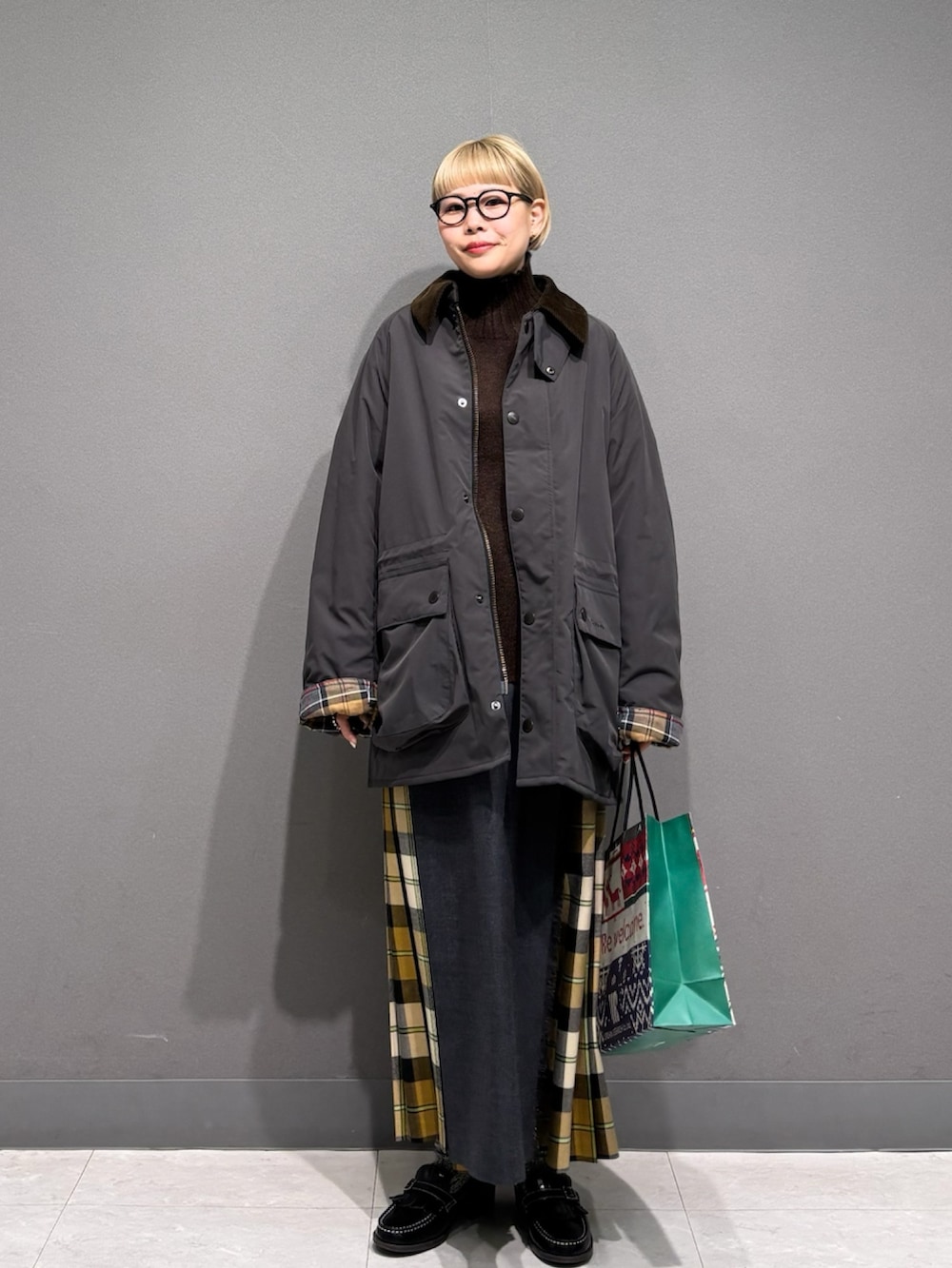 ブラウン系のニット/セーター、ベージュ系のスカート、グレー系のその他アウターを着用したレディースの冬コーディネートの2枚目の写真