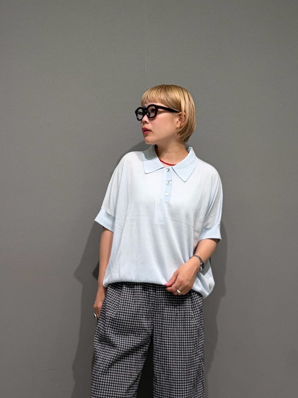 ブラック系のその他パンツ、ブルー系のニット/セーター、シルバー系のアナログ腕時計を着用したレディースの夏コーディネートの6枚目の写真
