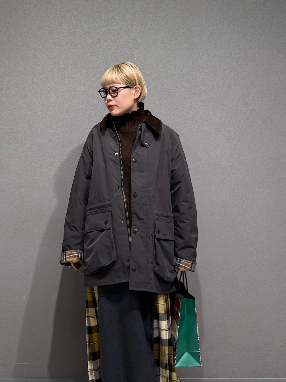 ブラウン系のニット/セーター、ベージュ系のスカート、グレー系のその他アウターを着用したレディースの冬コーディネートの5枚目の写真