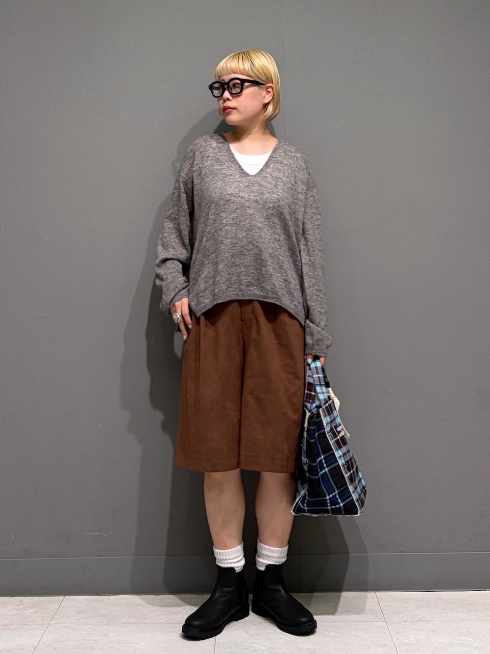 グレー系のニット/セーター、ブラウン系のその他パンツ、ブラック系のレインシューズを着用したレディースの秋コーディネートの7枚目の写真