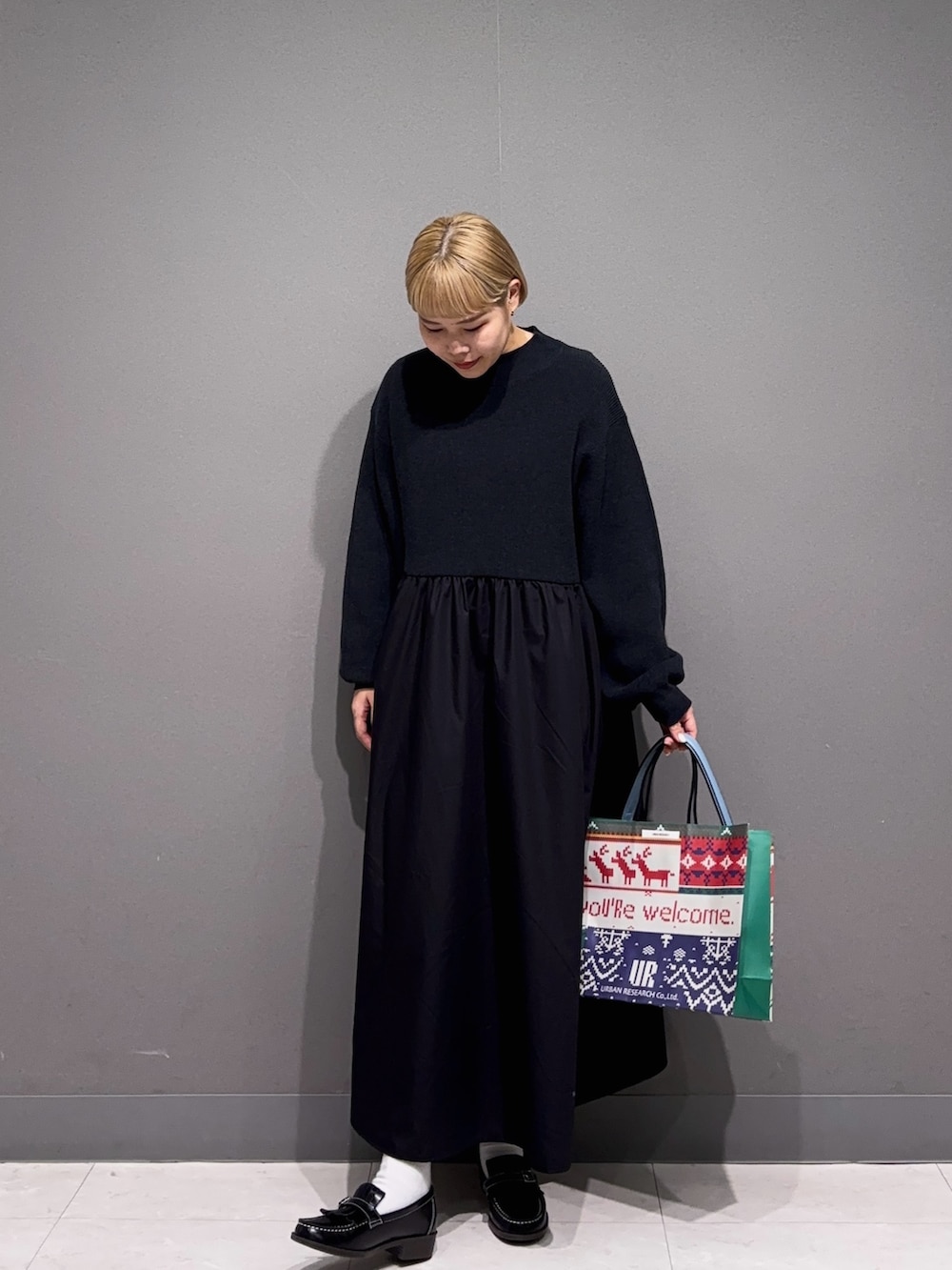 ブラック系のワンピース、ブラック系のローファー、ブルー系のバッグを着用したレディースの秋コーディネートの3枚目の写真