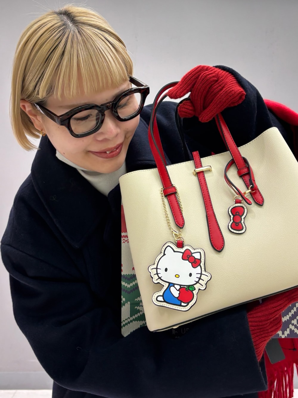 ホワイト系のハンドバッグ、ブルー系のその他アウター、レッド系のストール/ショールを着用したレディースの冬コーディネートの2枚目の写真