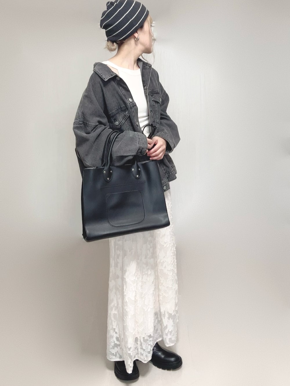 ホワイト系のタンクトップ、ブラック系のデニムジャケット、ブラック系のトートバッグを着用したレディースの秋コーディネートの4枚目の写真