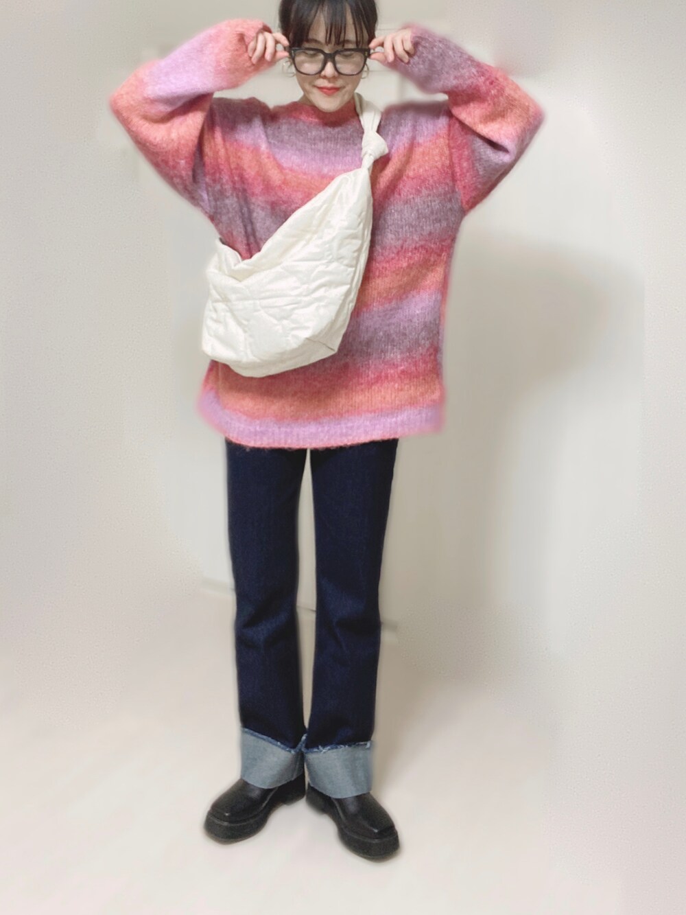 ピンク系のカーディガン/ボレロ、ホワイト系のショルダーバッグ、ブルー系のデニムパンツを着用したレディースの秋コーディネートの4枚目の写真