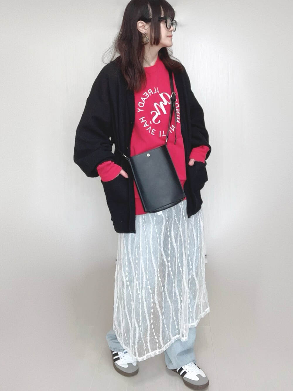 ブラック系のカーディガン/ボレロ、レッド系のスウェット、ブラック系のショルダーバッグを着用したレディースの春コーディネートの4枚目の写真