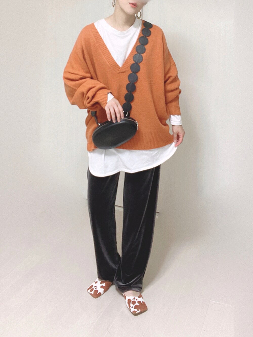 オレンジ系のニット/セーター、グレー系のその他パンツ、イエロー系のパンプスを着用したレディースの秋コーディネートの4枚目の写真