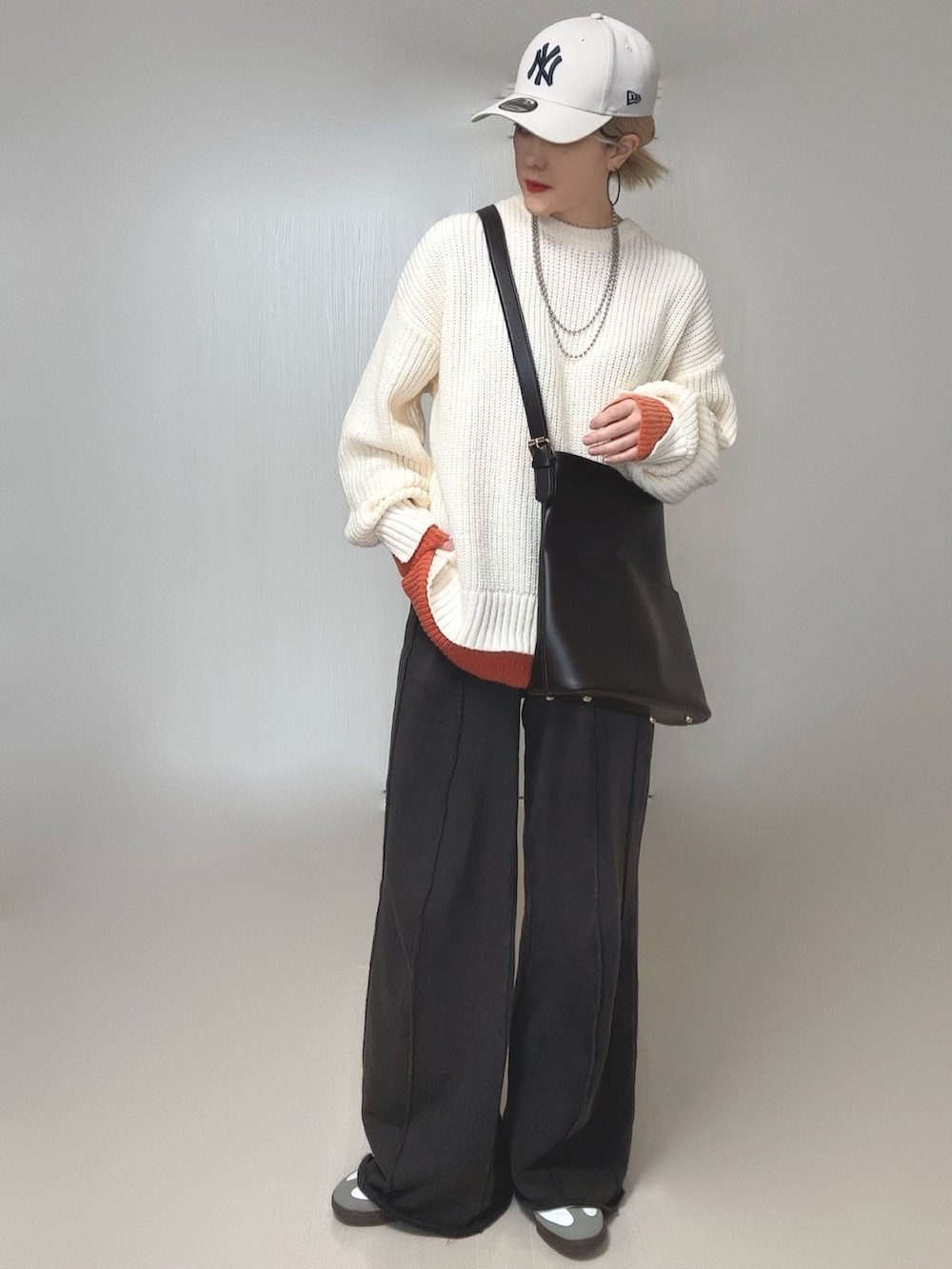 ブラック系のスウェットパンツ、ホワイト系のニット/セーター、ホワイト系のキャップを着用したレディースの冬コーディネートの4枚目の写真