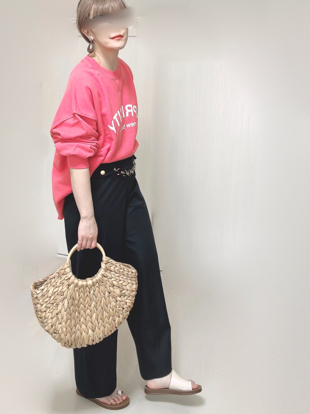 ピンク系のスウェット、ブルー系のスラックス、ベージュ系のかごバッグを着用したレディースの春コーディネートの3枚目の写真