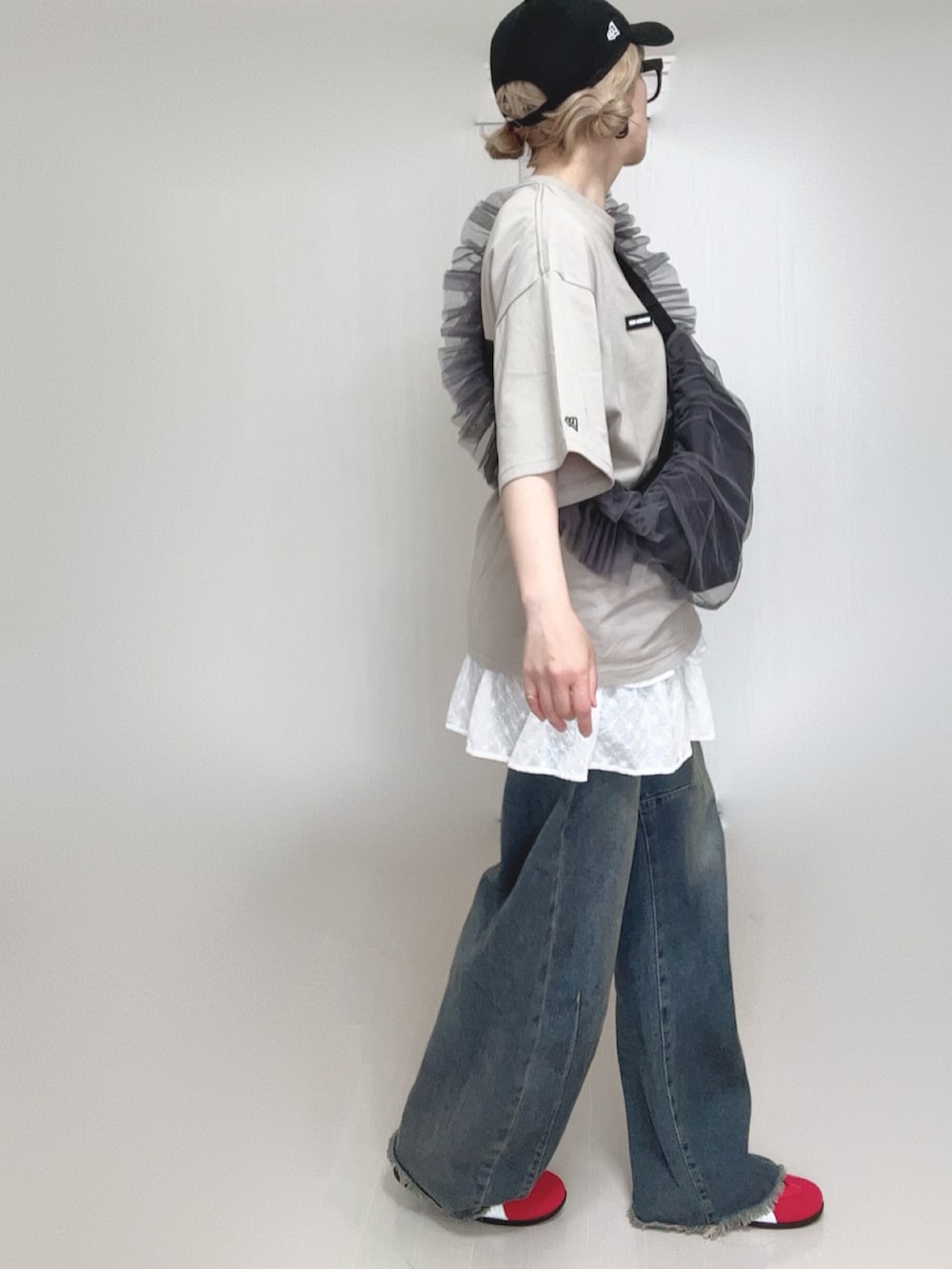 ブルー系のデニムパンツ、ホワイト系のスカート、グレー系のショルダーバッグを着用したレディースの夏コーディネートの5枚目の写真