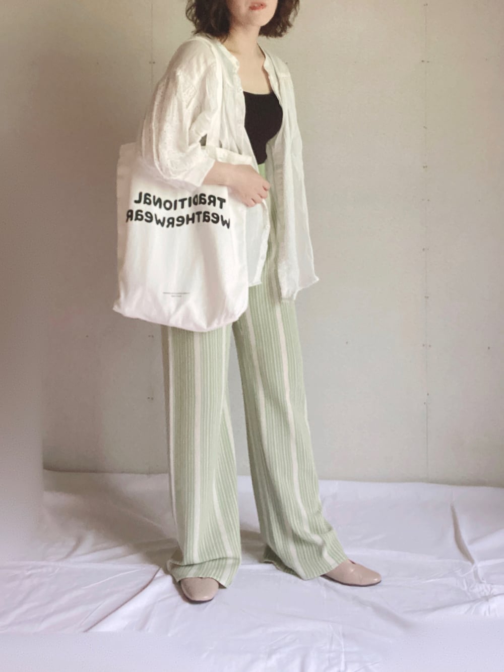 ホワイト系のシャツ/ブラウス、ホワイト系のトートバッグ、ベージュ系のパンプスを着用したレディースの夏コーディネートの5枚目の写真