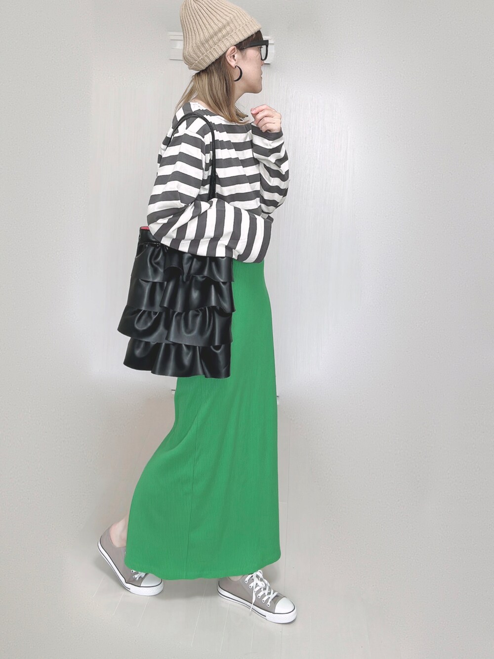 グリーン系のスカート、ベージュ系のニットキャップ/ビーニー、ブラック系のメガネを着用したレディースの秋コーディネートの4枚目の写真