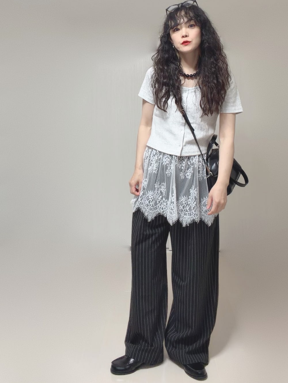 グレー系のTシャツ/カットソー、ブラック系のボストンバッグ、ブラック系のスラックスを着用したレディースの春コーディネートの4枚目の写真