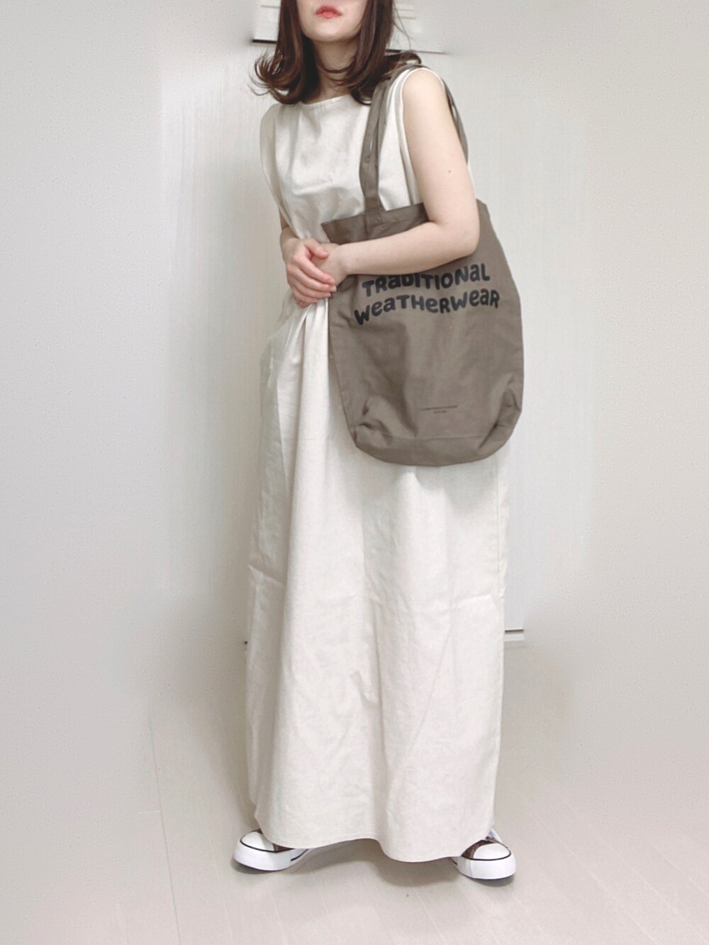 ホワイト系のワンピース、ブラウン系のトートバッグ、ブルー系のニットキャップ/ビーニーを着用したレディースの春コーディネートの2枚目の写真