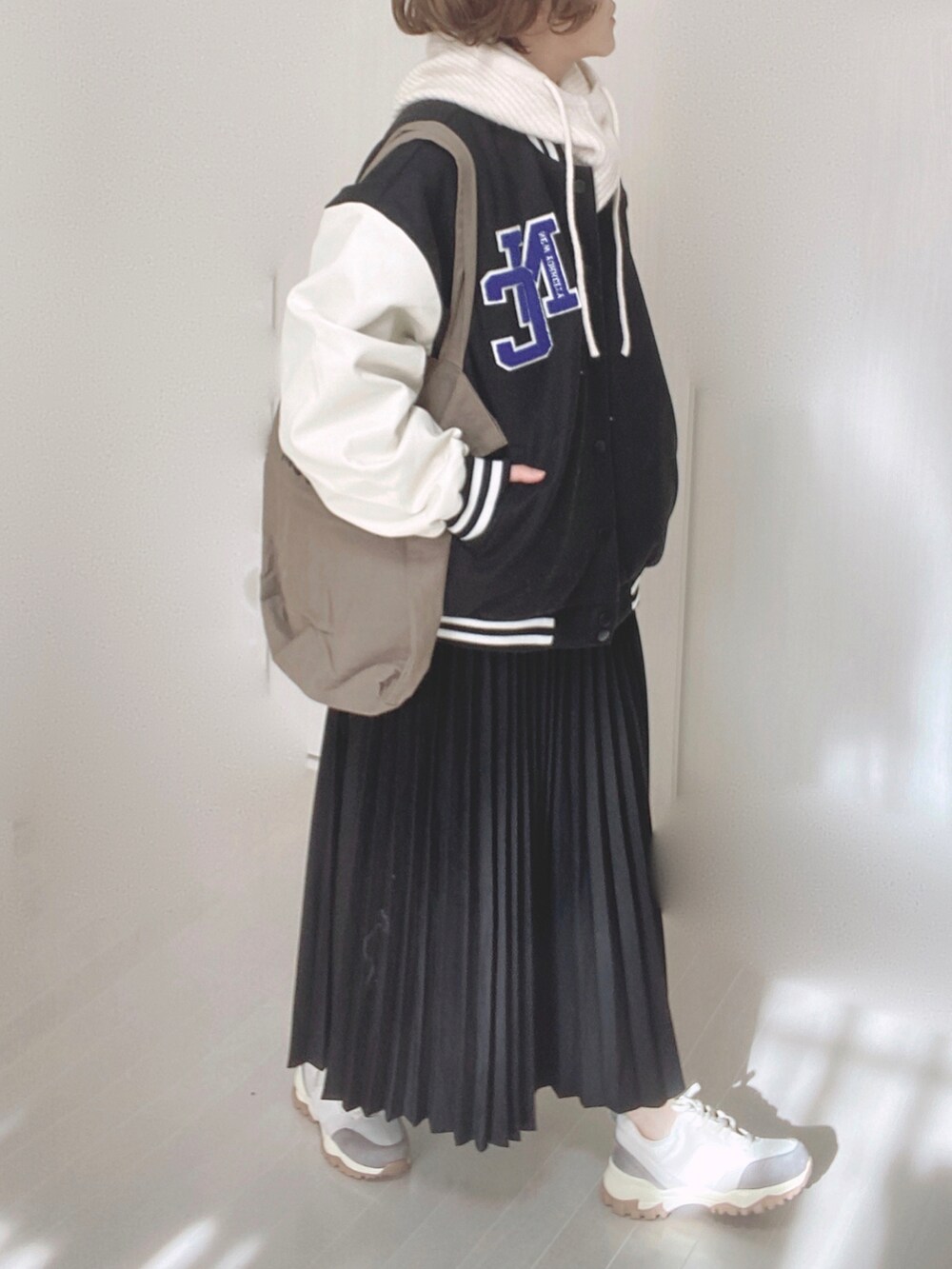 ベージュ系のスニーカー、ブラック系のスタジャン、ブラック系のスカートを着用したレディースの冬コーディネートの3枚目の写真