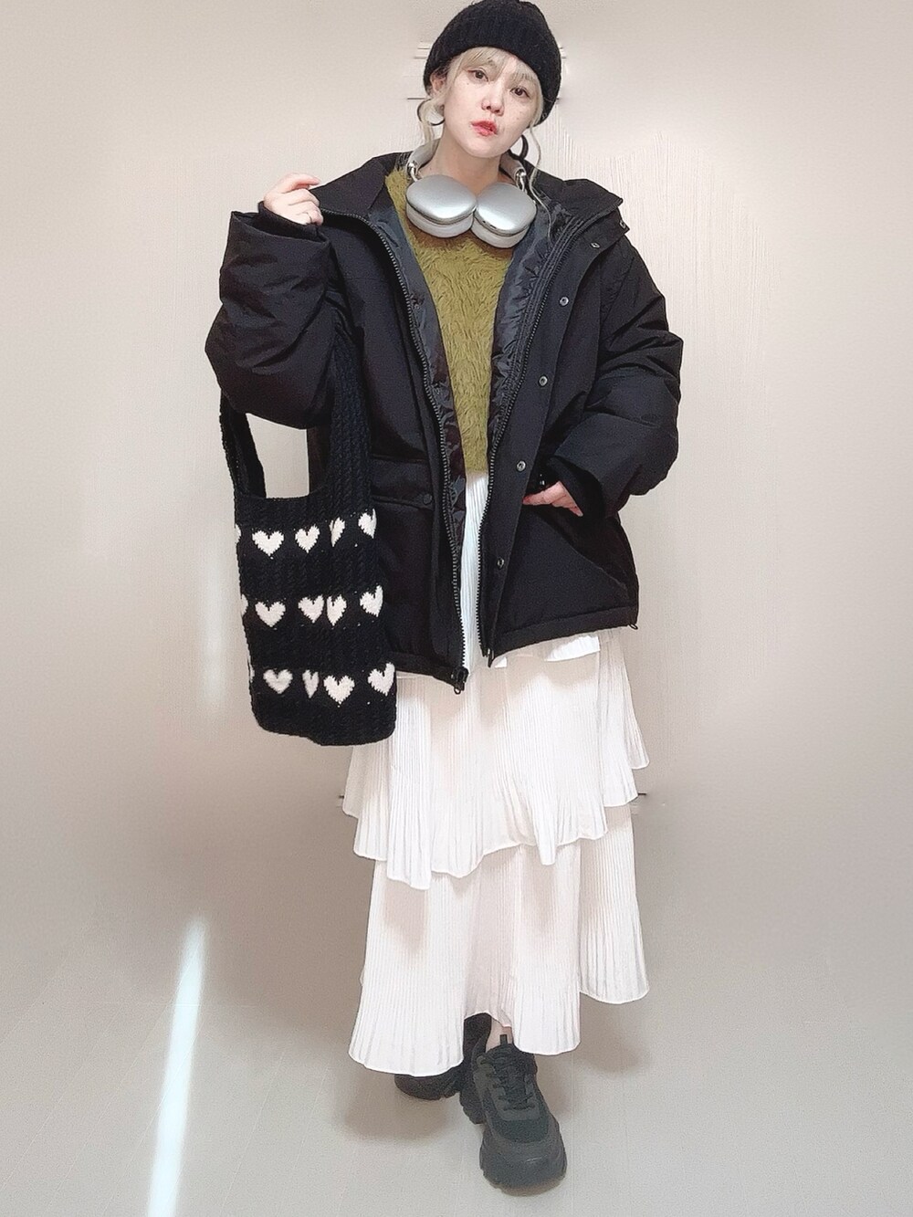 ブラック系のブルゾン、グリーン系のニット/セーター、ホワイト系のスカートを着用したレディースの冬コーディネートの4枚目の写真