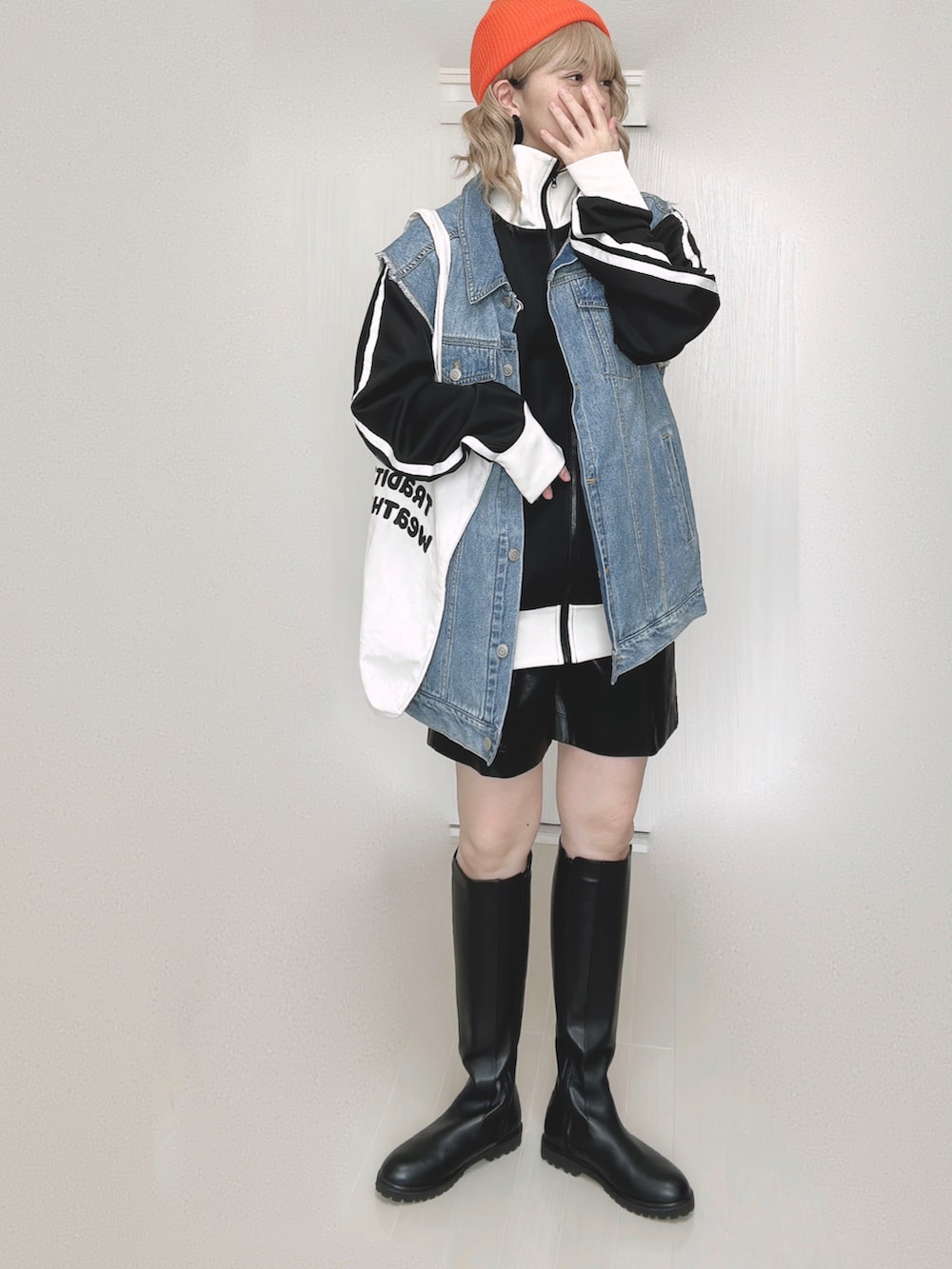 ブラック系のブルゾン、ブルー系のベスト、ホワイト系のトートバッグを着用したレディースの秋コーディネートの5枚目の写真