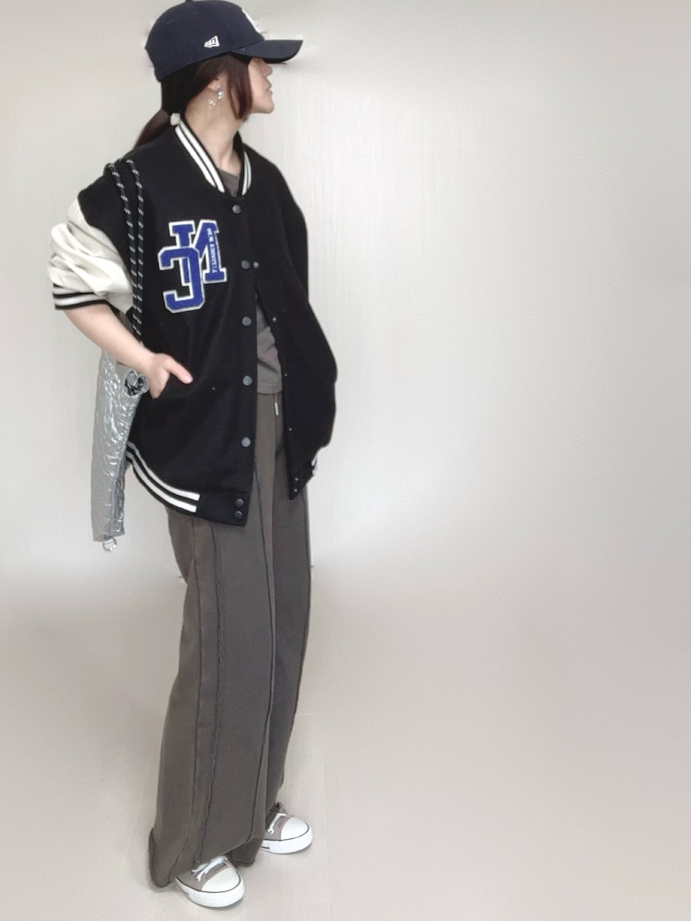 ブラック系のスウェットパンツ、ブラック系のスタジャン、シルバー系のトートバッグを着用したレディースの春コーディネートの4枚目の写真