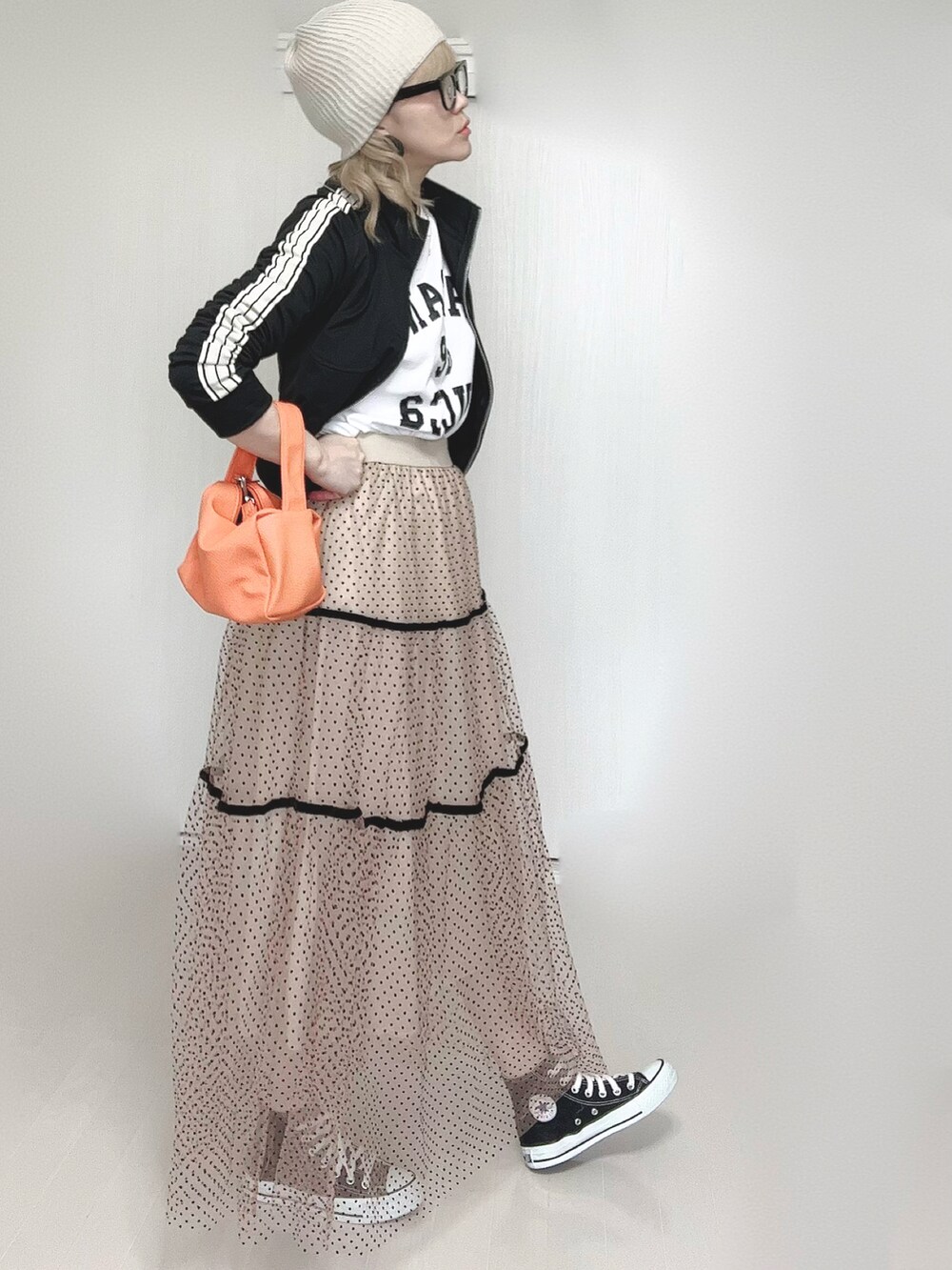 ベージュ系のスカート、ホワイト系のTシャツ/カットソー、ブラック系のジャージを着用したレディースの春コーディネートの3枚目の写真