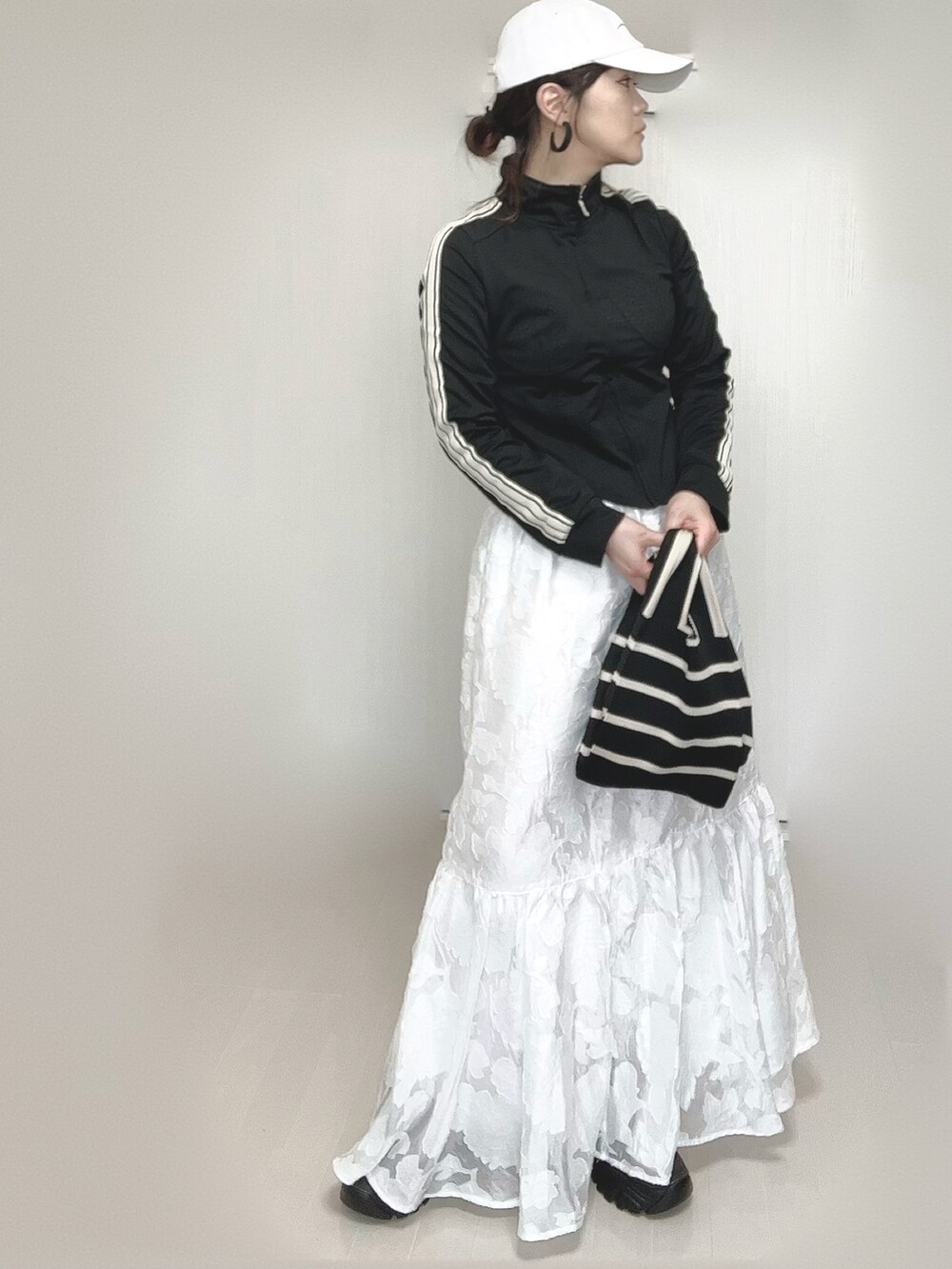 ブラック系のジャージ、その他のトートバッグ、ホワイト系のスカートを着用したレディースの春コーディネートの3枚目の写真