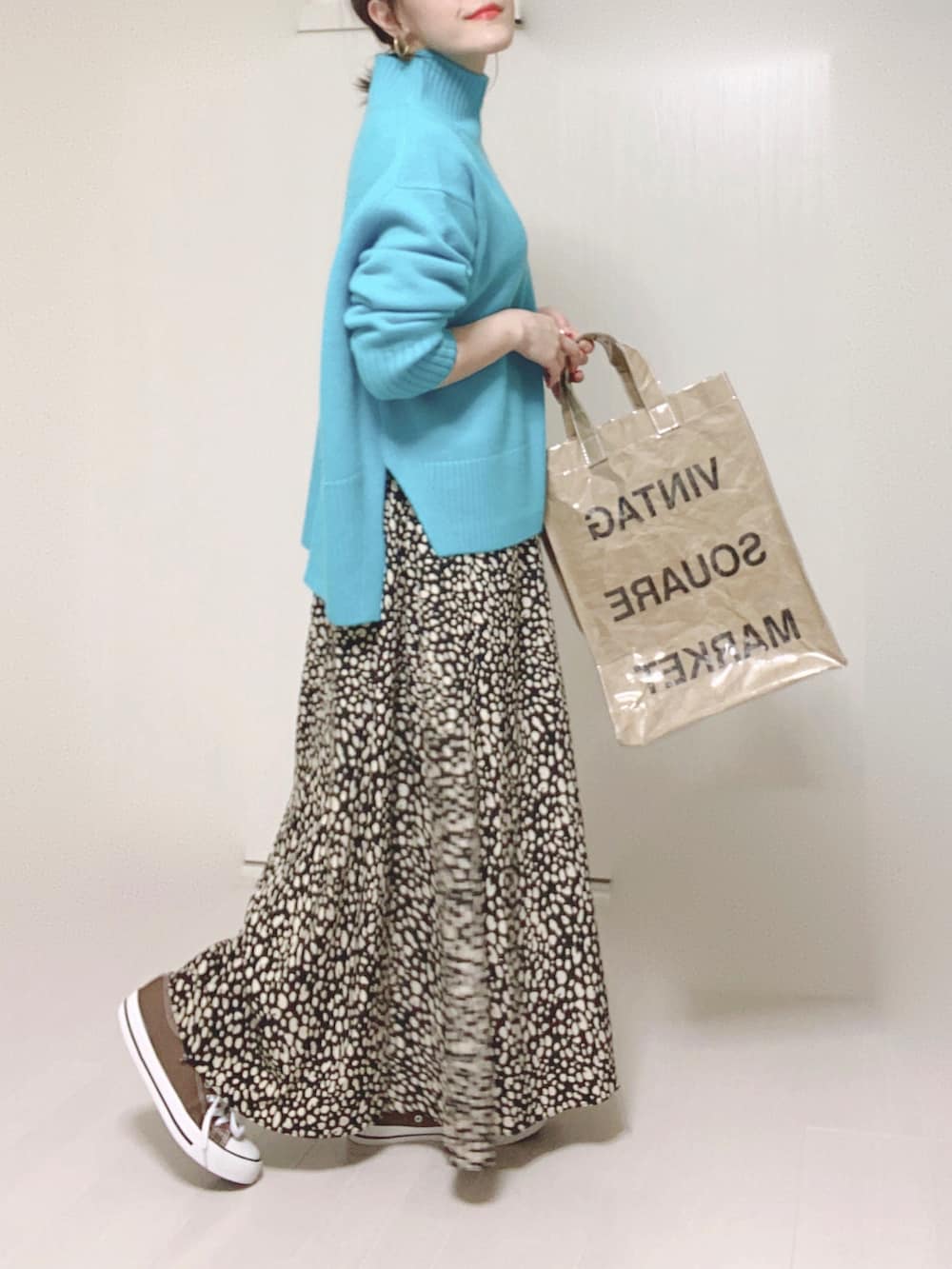 ブルー系のニット/セーター、グリーン系のトートバッグ、ブラック系のスカートを着用したレディースの秋コーディネートの3枚目の写真