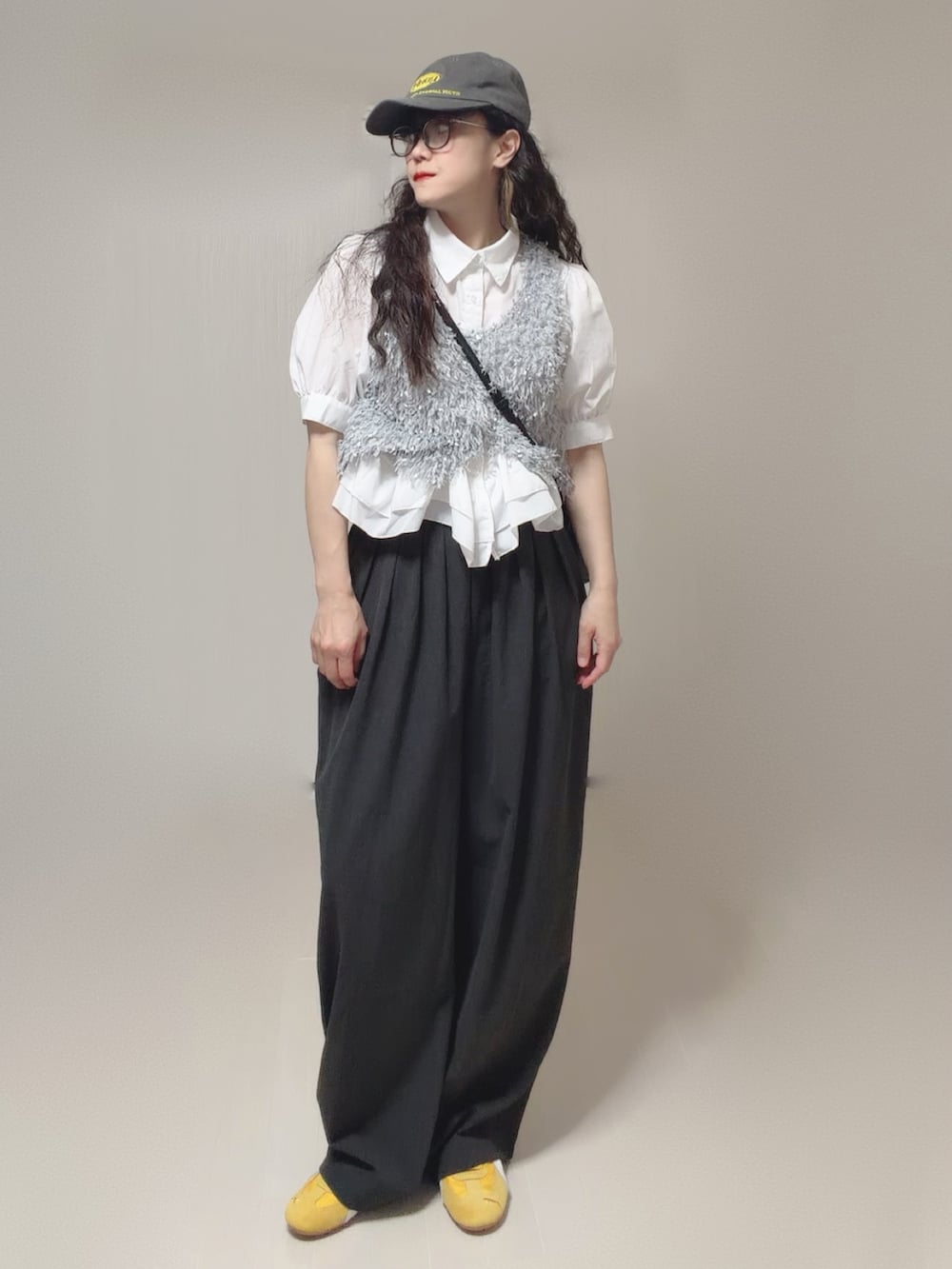 ホワイト系のシャツ/ブラウス、グレー系のベスト、グレー系のスラックスを着用したレディースの夏コーディネートの4枚目の写真
