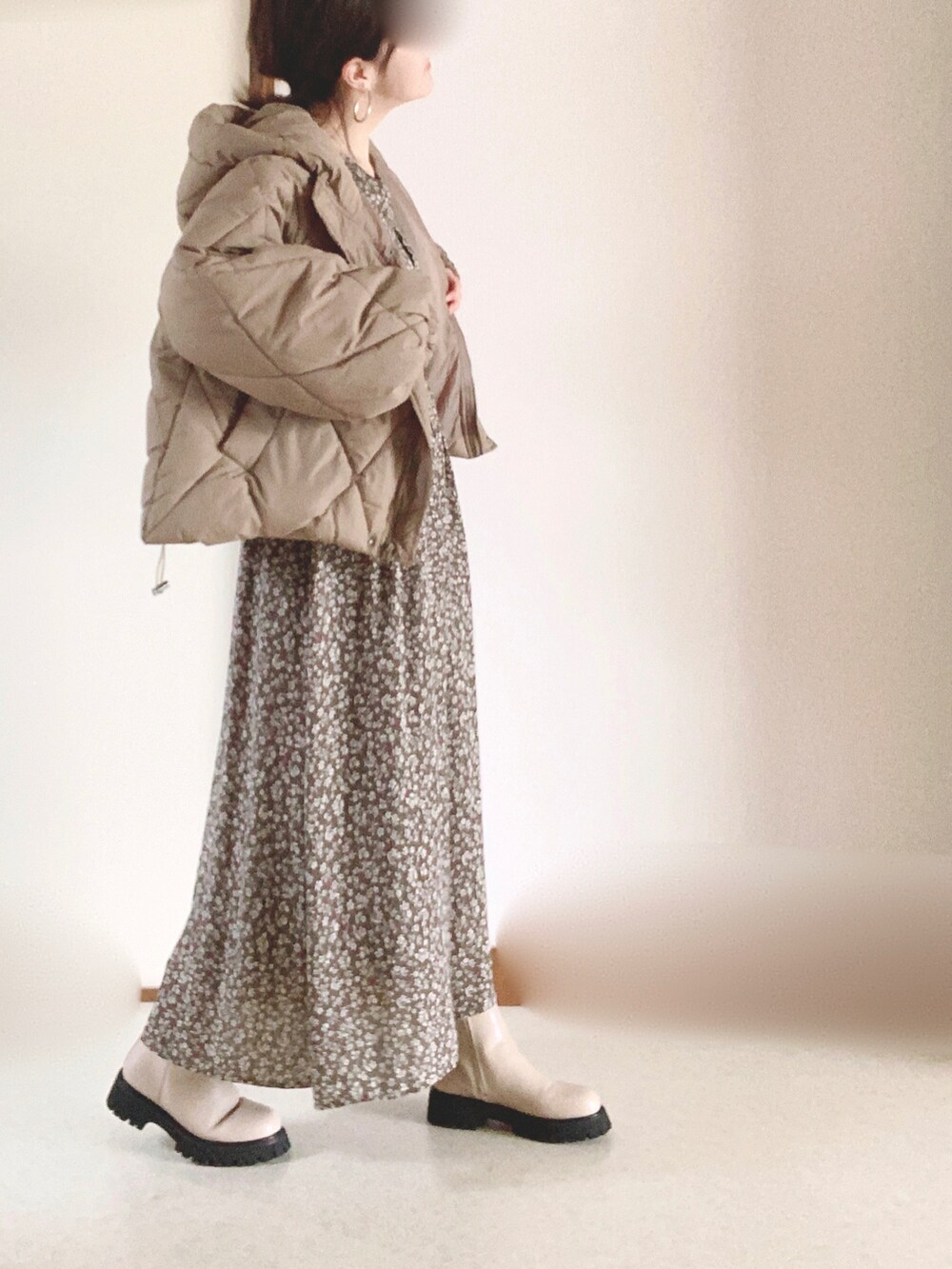 ブラウン系のダウンジャケット/コート、ブラウン系のワンピース、ベージュ系のブーツを着用したレディースの冬コーディネートの3枚目の写真