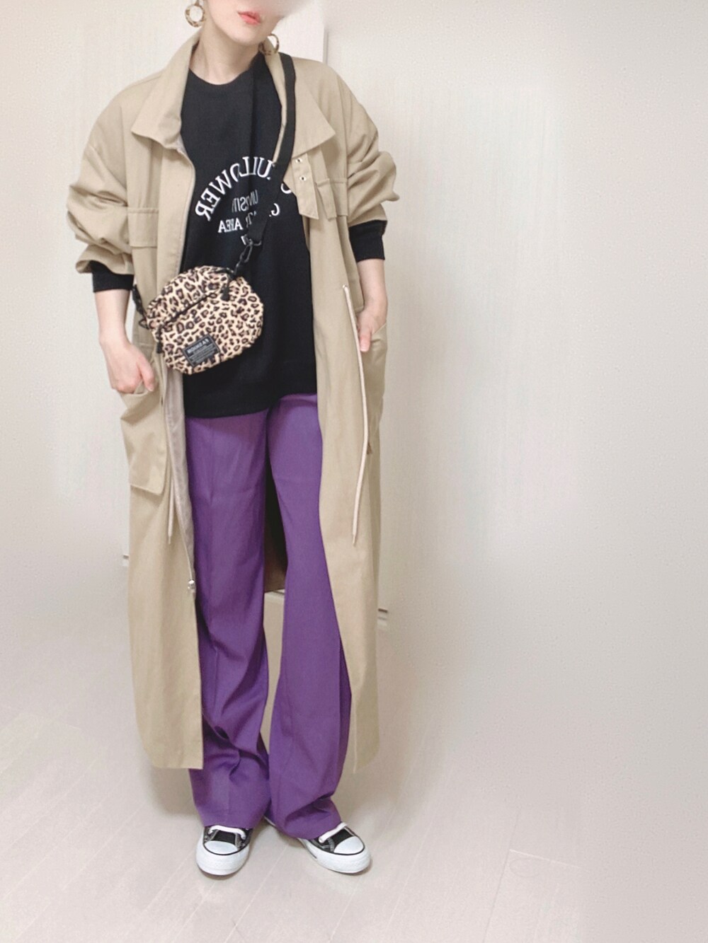ブラック系のスウェット、パープル系のスラックス、ベージュ系のその他アウターを着用したレディースの秋コーディネートの2枚目の写真