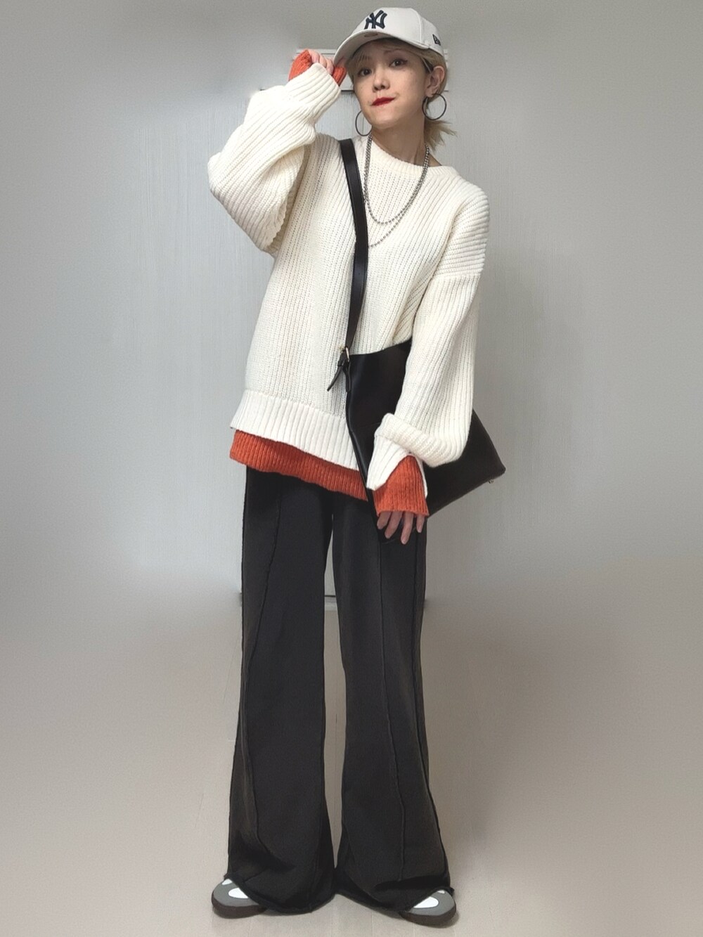 ブラック系のスウェットパンツ、ホワイト系のニット/セーター、ホワイト系のキャップを着用したレディースの冬コーディネートの5枚目の写真