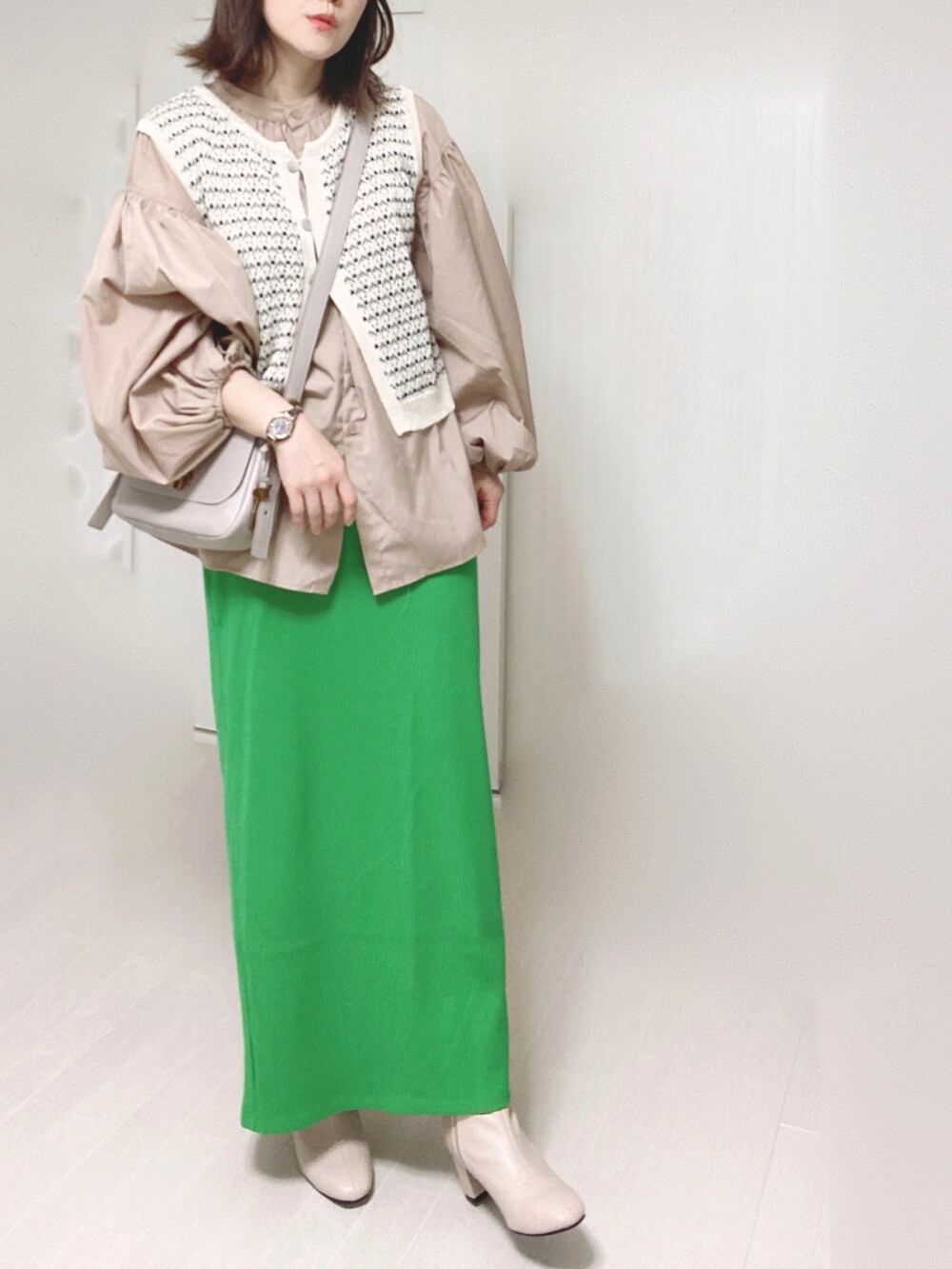 グレー系のメッセンジャーバッグ、ベージュ系のシャツ/ブラウス、グリーン系のスカートを着用したレディースの秋コーディネートの5枚目の写真