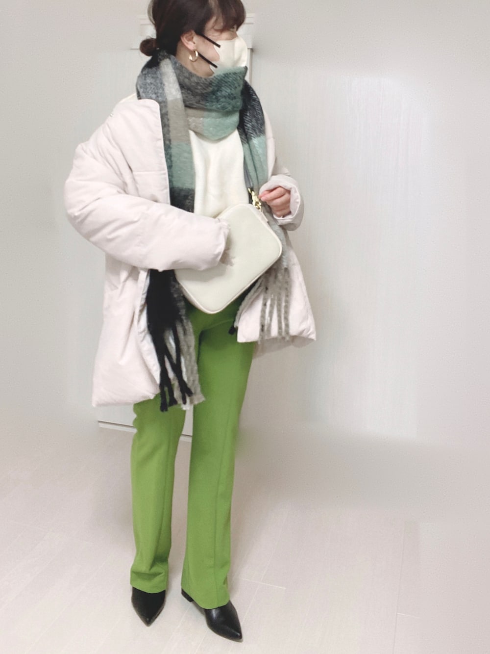 ホワイト系のショルダーバッグ、ホワイト系のダウンジャケット/コート、ホワイト系のニット/セーターを着用したレディースの冬コーディネートの5枚目の写真