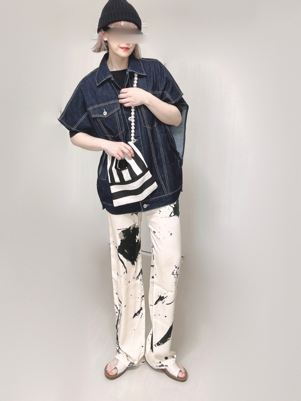 ブルー系のベスト、ブラック系のTシャツ/カットソー、ホワイト系のショルダーバッグを着用したレディースの春コーディネートの2枚目の写真