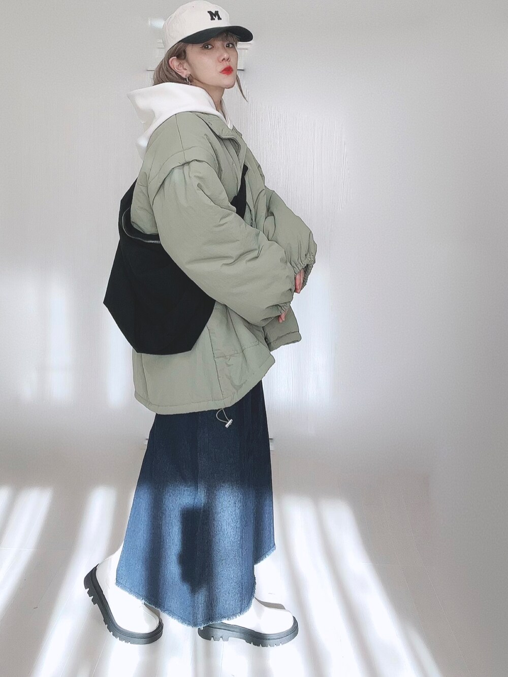 グリーン系のダウンジャケット/コート、ホワイト系のパーカー、ブルー系のセットアップを着用したレディースの冬コーディネートの5枚目の写真