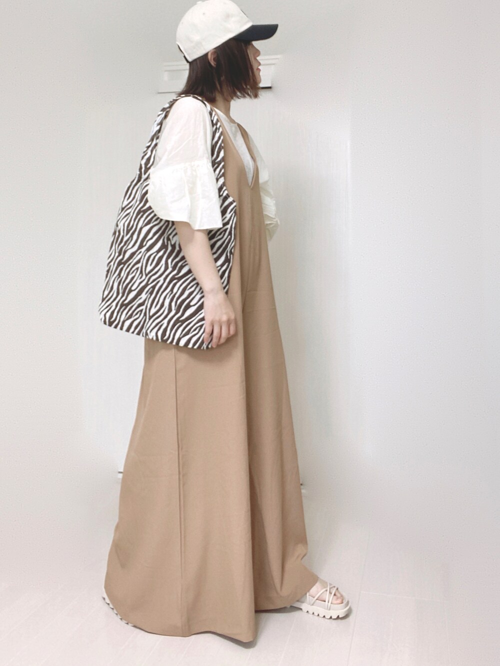 ベージュ系のサロペット/オーバーオール、ホワイト系のシャツ/ブラウス、ホワイト系のサンダルを着用したレディースの夏コーディネートの5枚目の写真