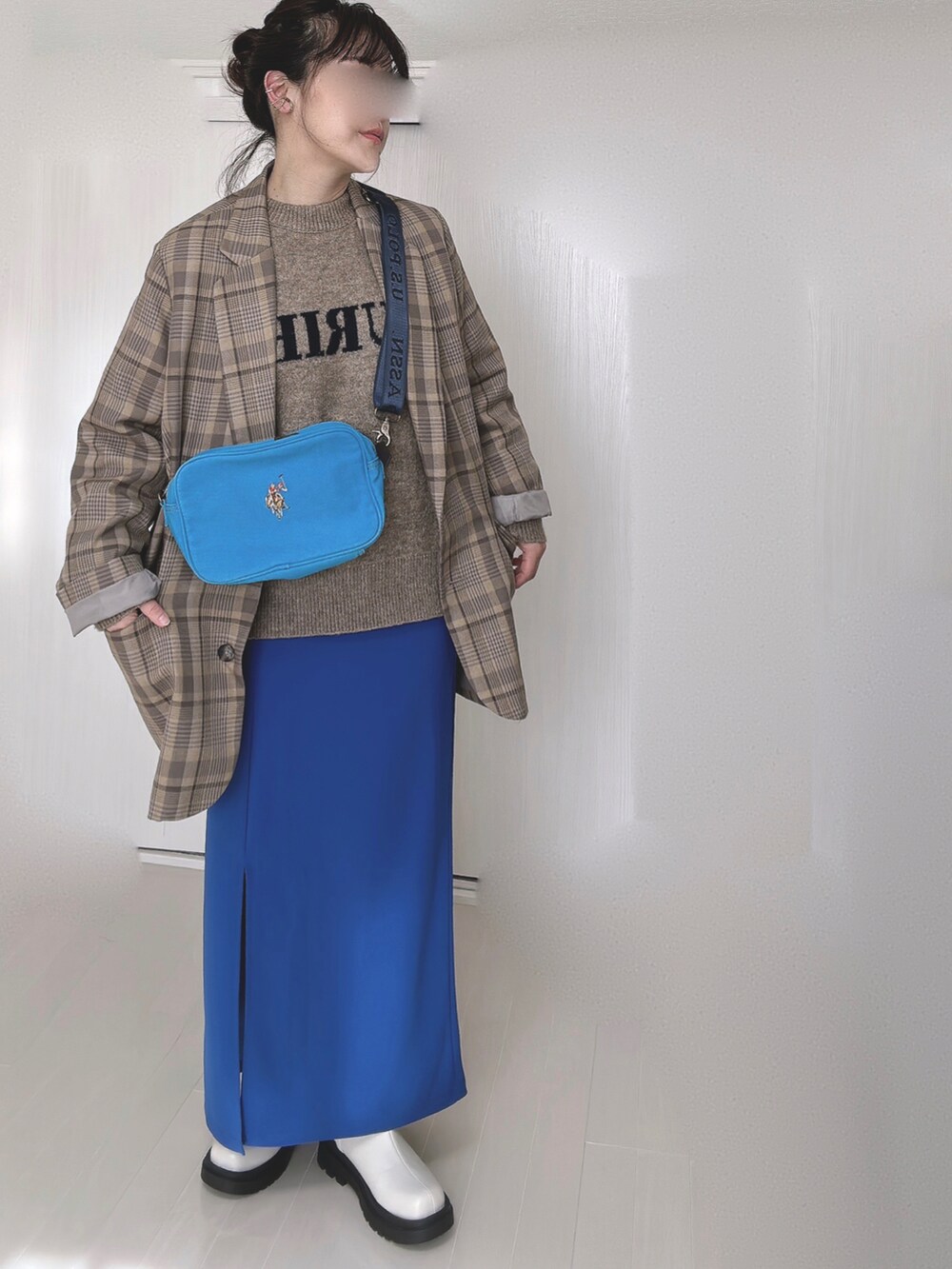 ブルー系のショルダーバッグ、ベージュ系のテーラードジャケット、ベージュ系のニット/セーターを着用したレディースの冬コーディネートの4枚目の写真