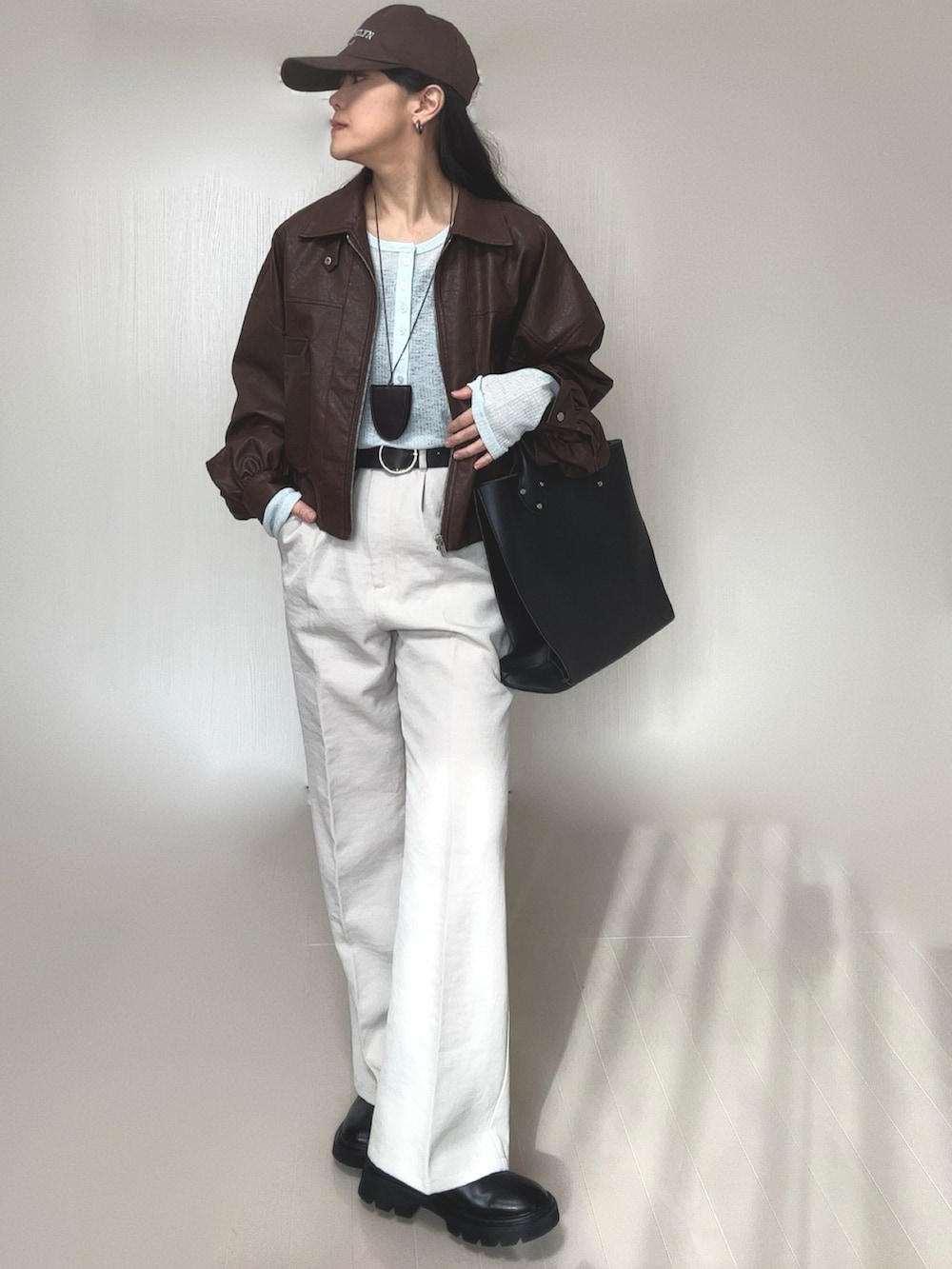 ブルー系のTシャツ/カットソー、ブラウン系のブルゾン、ブラック系のトートバッグを着用したレディースの冬コーディネートの5枚目の写真