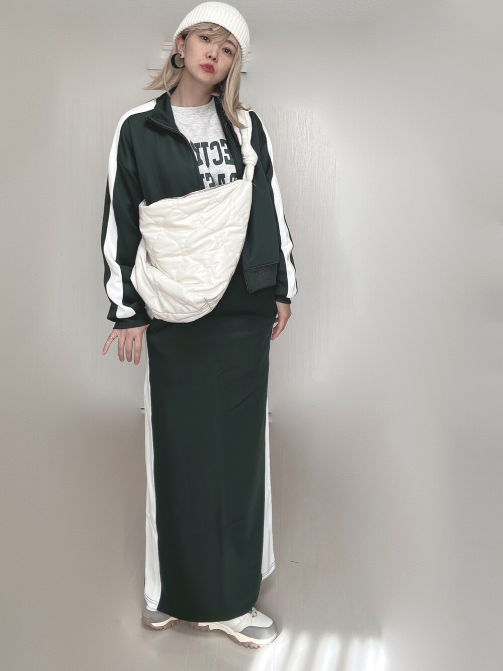 グリーン系のその他アウター、グリーン系のスカート、ホワイト系のショルダーバッグを着用したレディースの秋コーディネートの5枚目の写真