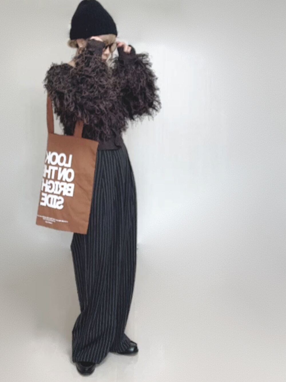 ブラック系のカーディガン/ボレロ、ブラック系のスラックス、ブラック系のローファーを着用したレディースの秋コーディネートの5枚目の写真