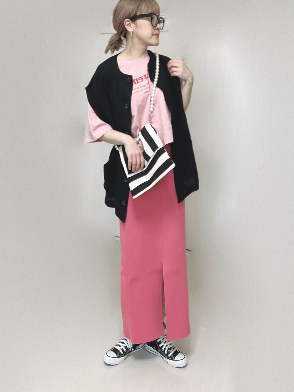 ブラック系のベスト、ホワイト系のショルダーバッグ、ピンク系のスカートを着用したレディースの夏コーディネートの5枚目の写真