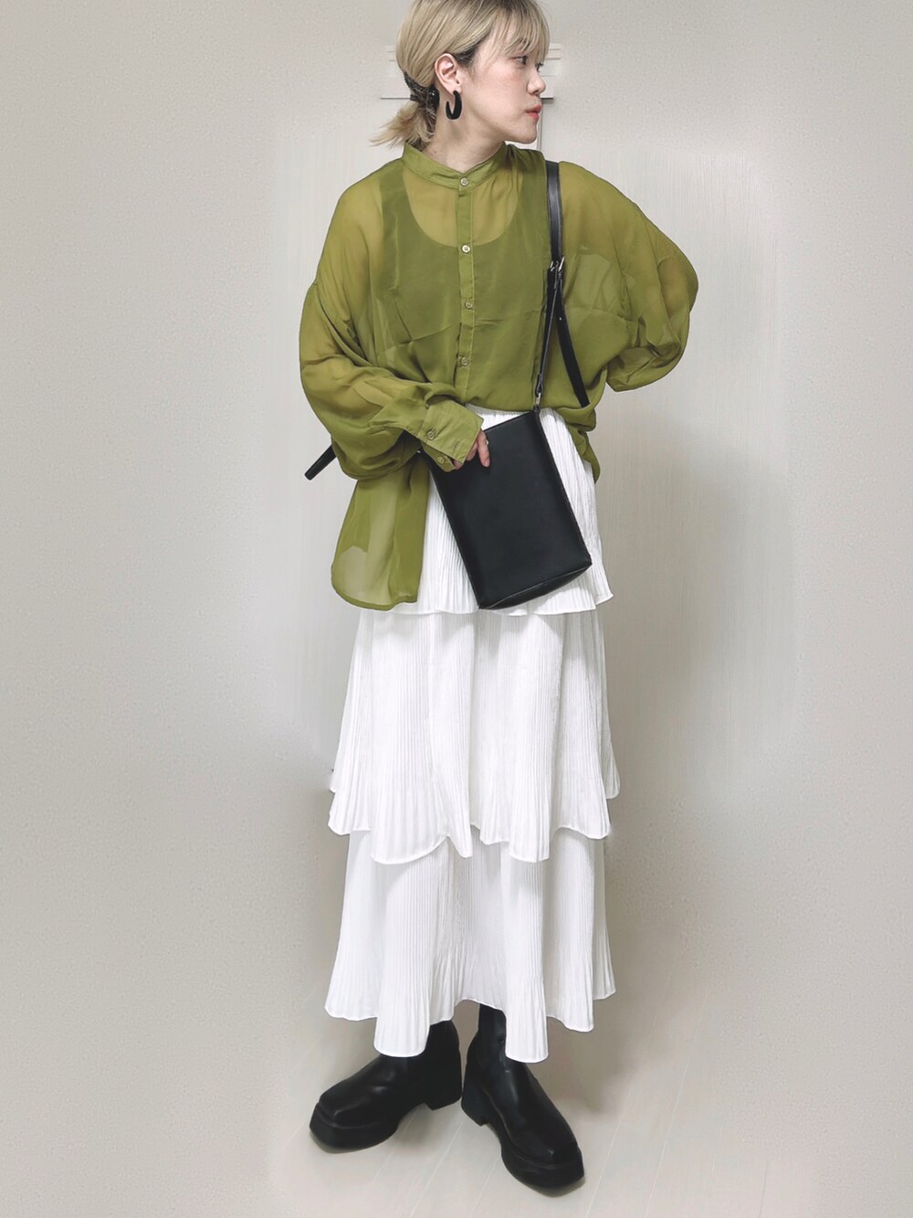 ホワイト系のスカート、グリーン系のシャツ/ブラウス、ブラック系のブーツを着用したレディースの秋コーディネートの3枚目の写真