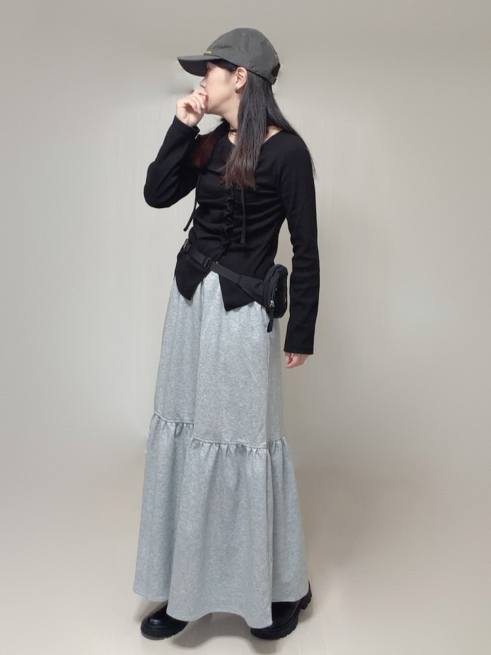 ブラック系のTシャツ/カットソー、グレー系のスカート、ブラック系のボディバッグ/ウエストポーチを着用したレディースの秋コーディネートの3枚目の写真