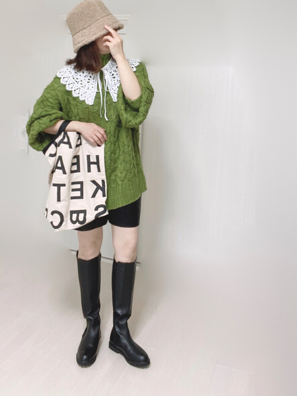 ブラック系のブーツ、グリーン系のニット/セーター、ホワイト系のトートバッグを着用したレディースの秋コーディネートの5枚目の写真