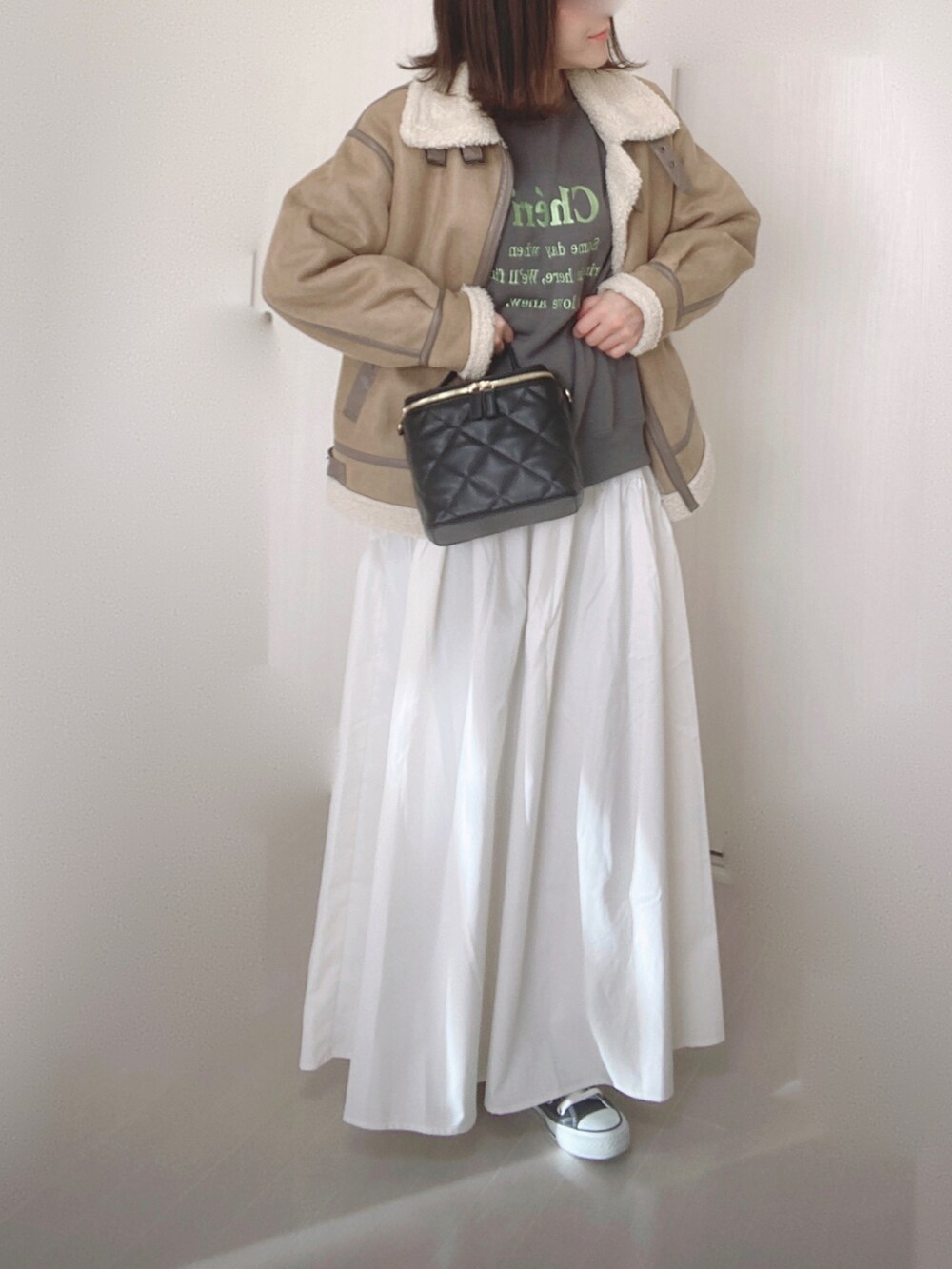 グレー系のスウェット、ホワイト系のスカート、ベージュ系のムートンコートを着用したレディースの冬コーディネートの5枚目の写真