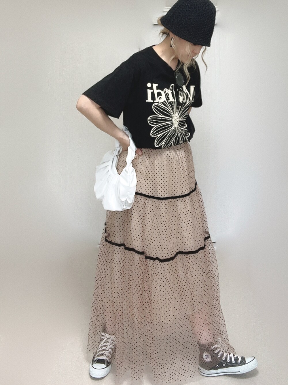 ブラック系のTシャツ/カットソー、ベージュ系のスカート、ブラック系のスニーカーを着用したレディースの夏コーディネートの2枚目の写真