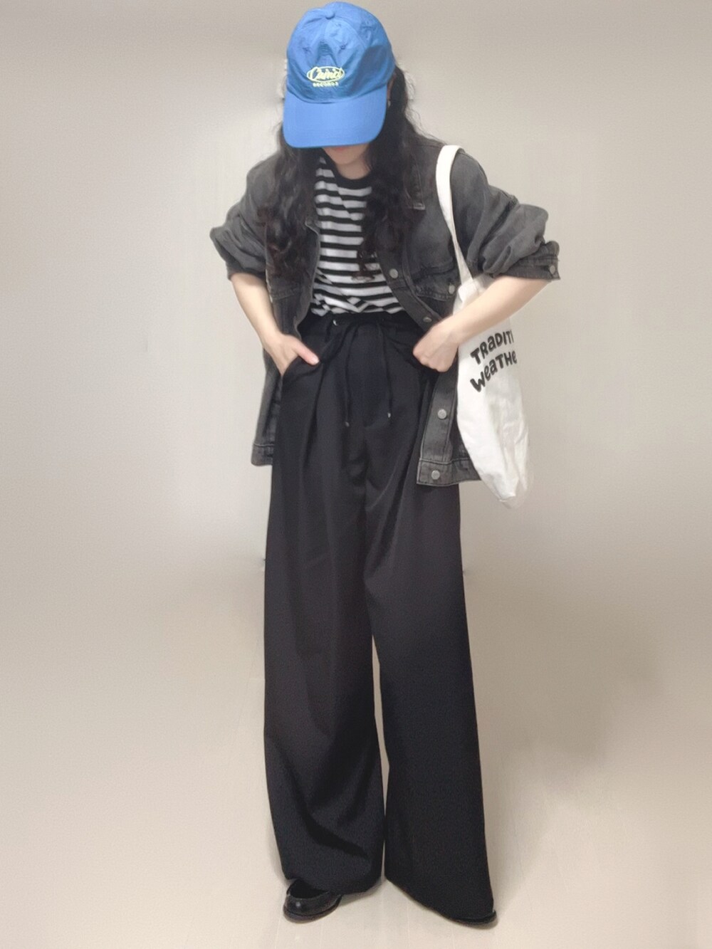 ブラック系のデニムジャケット、ブラック系のスラックス、ホワイト系のTシャツ/カットソーを着用したレディースの春コーディネートの5枚目の写真
