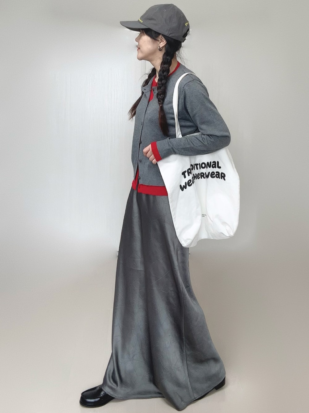 グレー系のカーディガン/ボレロ、グレー系のスカート、ブラック系のローファーを着用したレディースの冬コーディネートの2枚目の写真