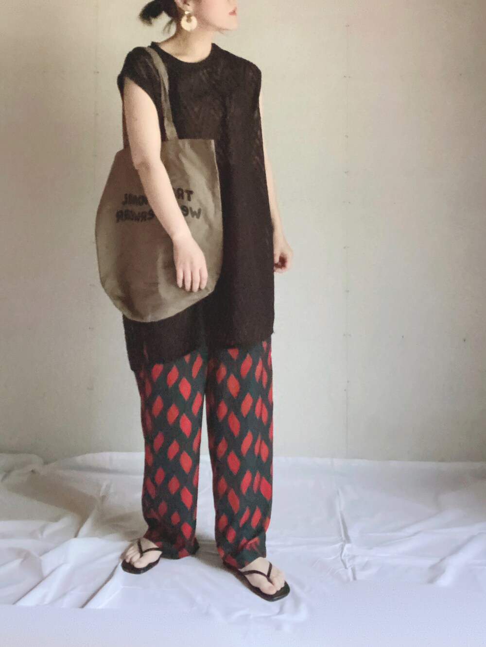 グリーン系のその他パンツ、ブラック系のベスト、ブラウン系のトートバッグを着用したレディースの夏コーディネートの2枚目の写真