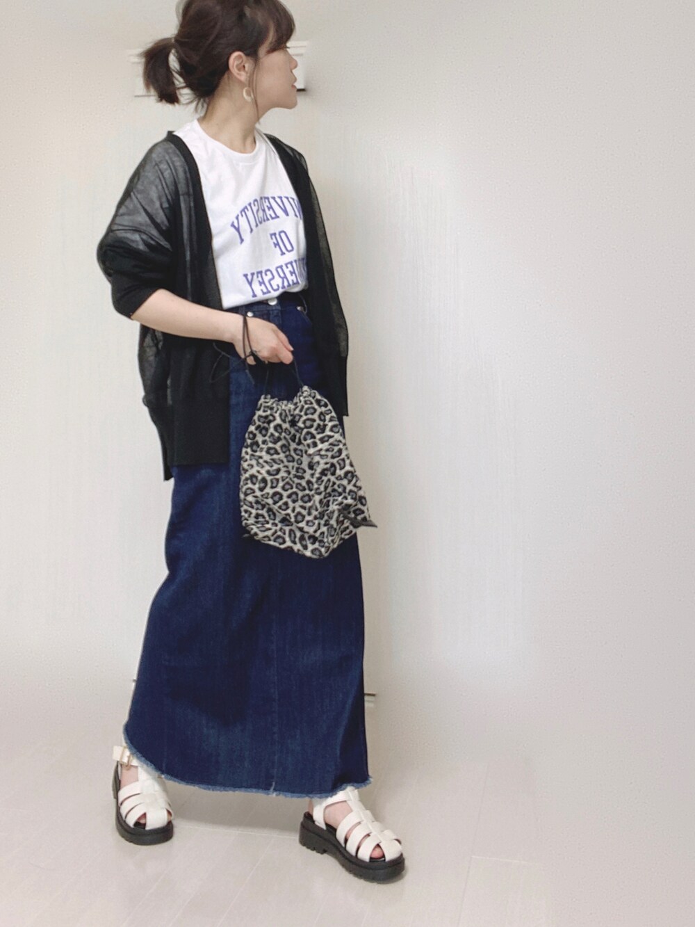 ブルー系のデニムスカート、ホワイト系のTシャツ/カットソー、ブラック系のカーディガン/ボレロを着用したレディースの夏コーディネートの2枚目の写真