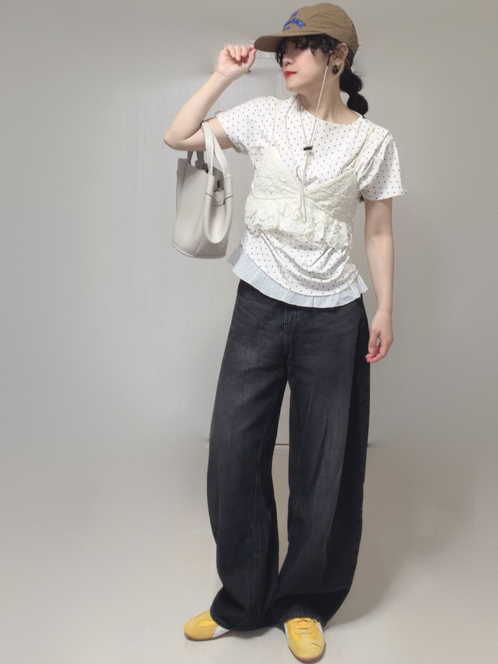 ホワイト系のTシャツ/カットソー、ブラック系のデニムパンツ、ホワイト系のキャミソールを着用したレディースの春コーディネートの5枚目の写真